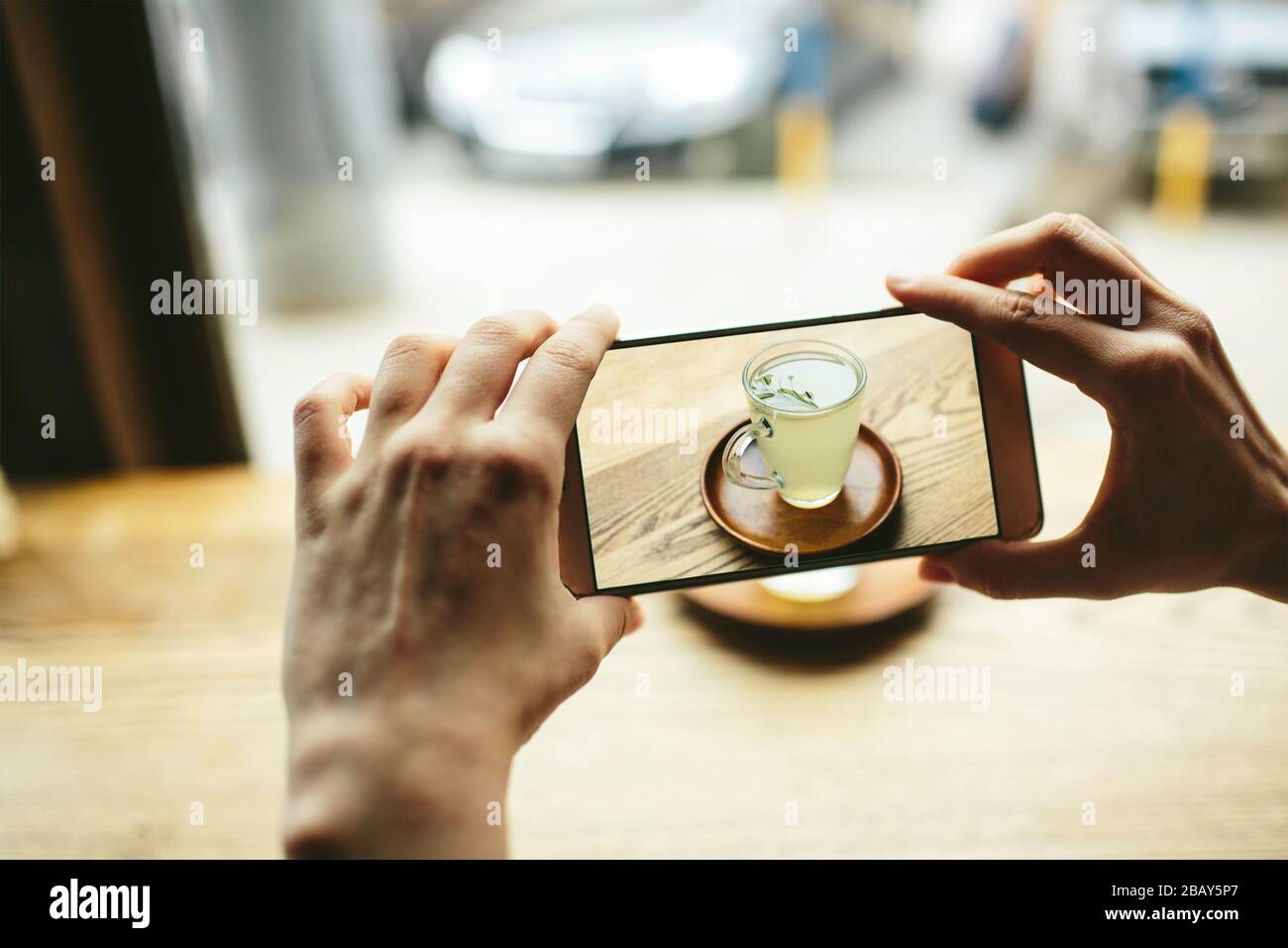 Yang donne scattare foto di tè verde con smartphone Foto Stock