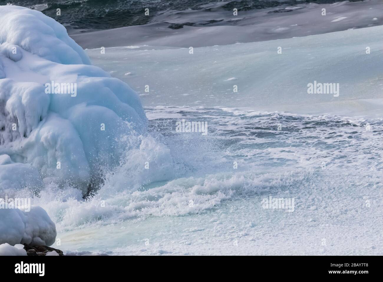 Onde dell'Oceano Atlantico piene di frammenti di ghiaccio che rotolano lungo la costa di Fogo Island, Terranova, Canada Foto Stock