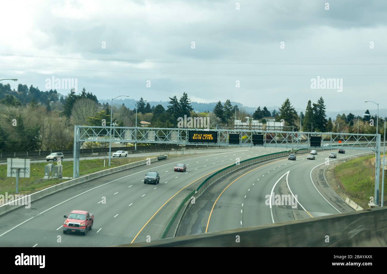 Portland, OR / USA - 29 marzo 2020: Segnale elettronico sulla superstrada i84 che informa le persone di rimanere a casa e salvare vite umane riducendo il rischio di essere infettati Foto Stock
