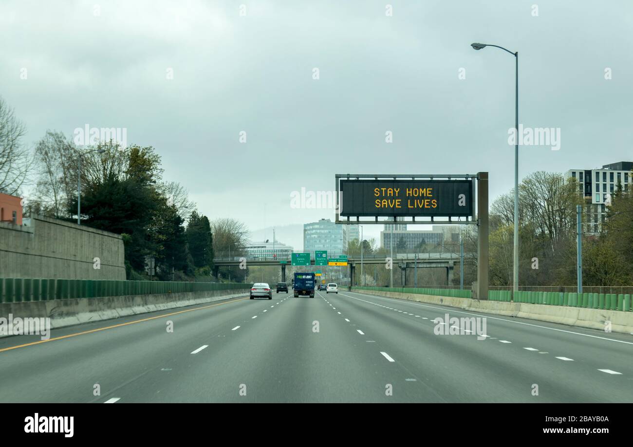 Portland, OR / USA - 29 marzo 2020: Segnale elettronico sulla superstrada i84 che informa le persone di rimanere a casa e salvare vite umane riducendo il rischio di essere infettati Foto Stock