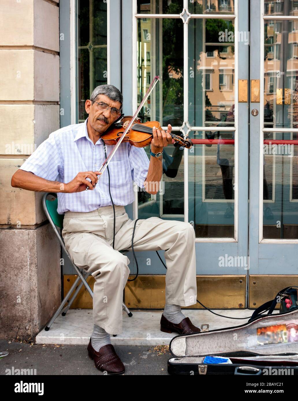 Ritratto di un uomo che suona un violino su un marciapiede nel centro di Roma, Lazio, Italia, Europa, colore Foto Stock