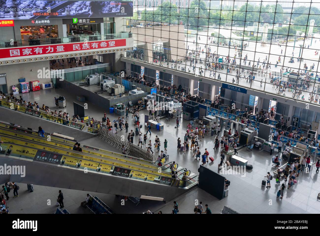 Passeggeri al punto di controllo di sicurezza in una stazione ferroviaria trafficata in Cina Foto Stock