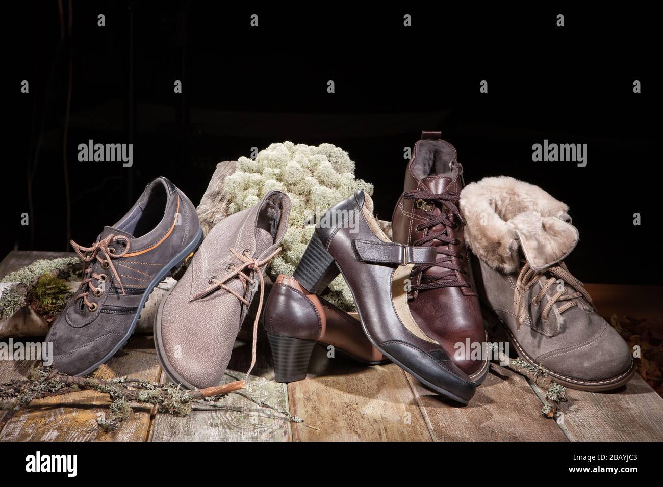 Diversi tipi di scarpe su una scrivania in legno Foto Stock