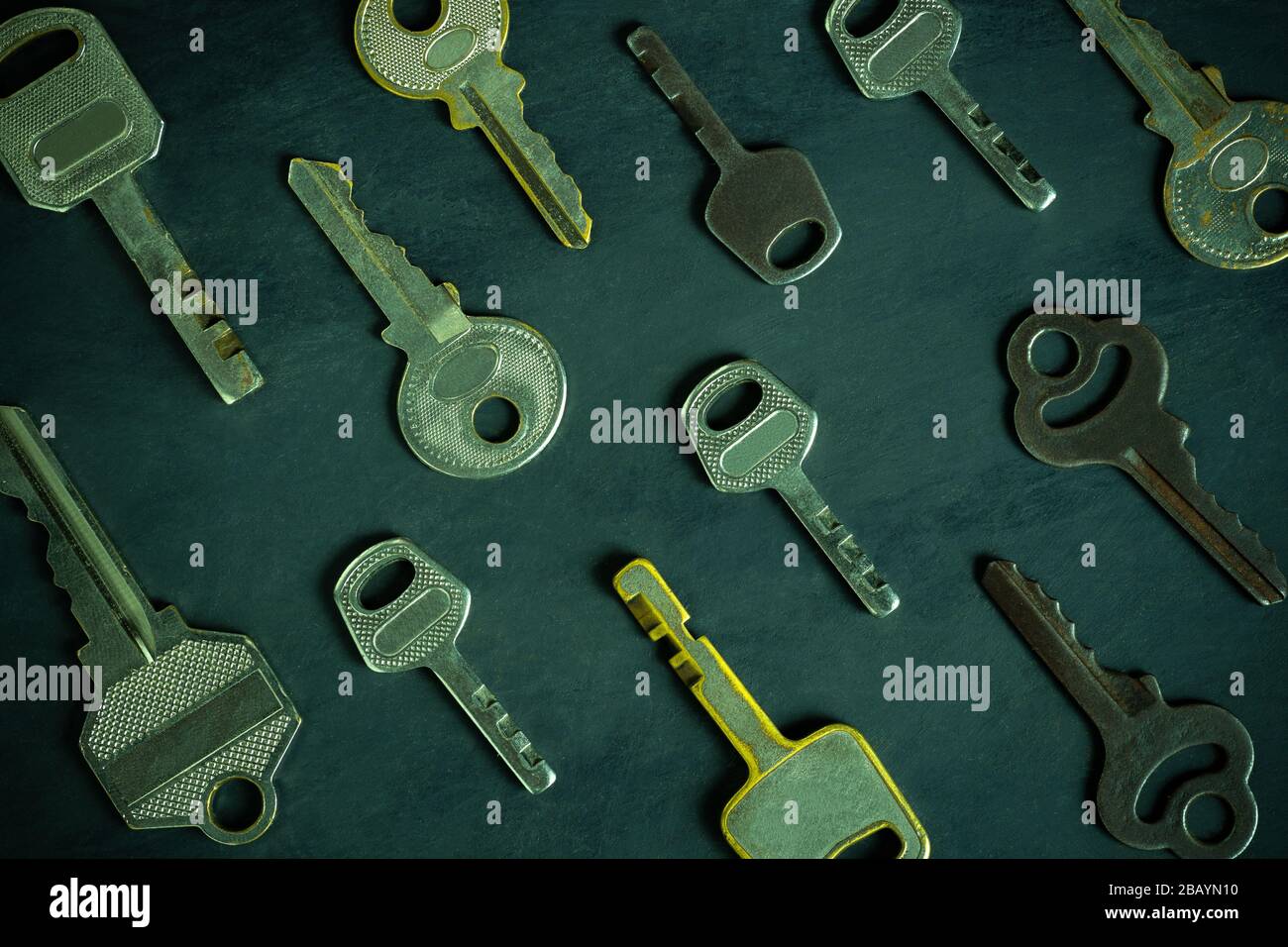 Chiudete la varietà molto diversa di chiavi vintage ordinate su tavola di legno nero in sfondo scuro. L'idea della chiave per risolvere il problema aziendale Foto Stock