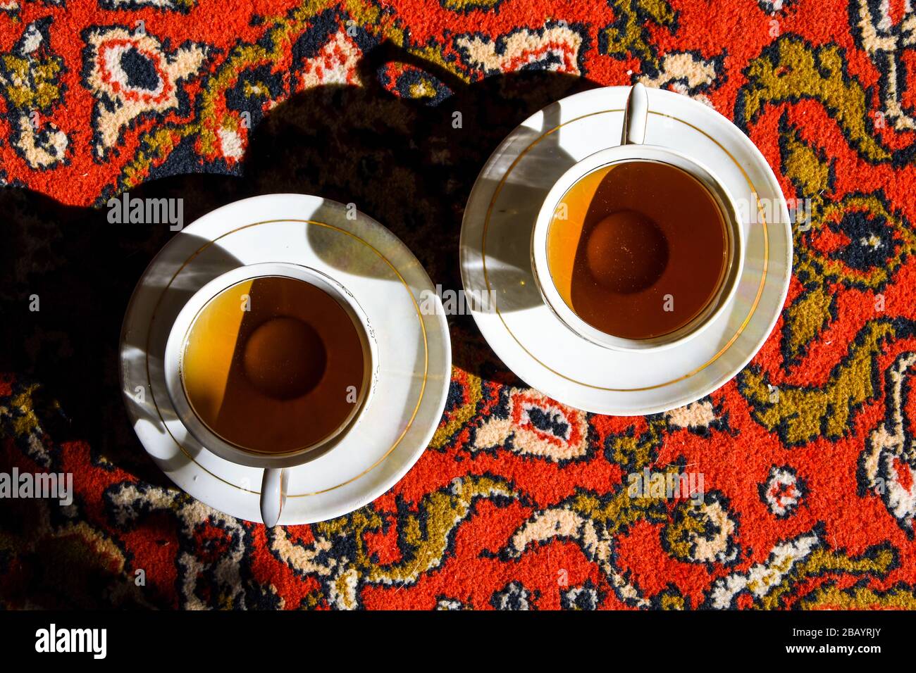 Due tazze di porcellana d'epoca di caffè o tè sul tappeto orientale turco o asiatico, cerimonia del tè Foto Stock