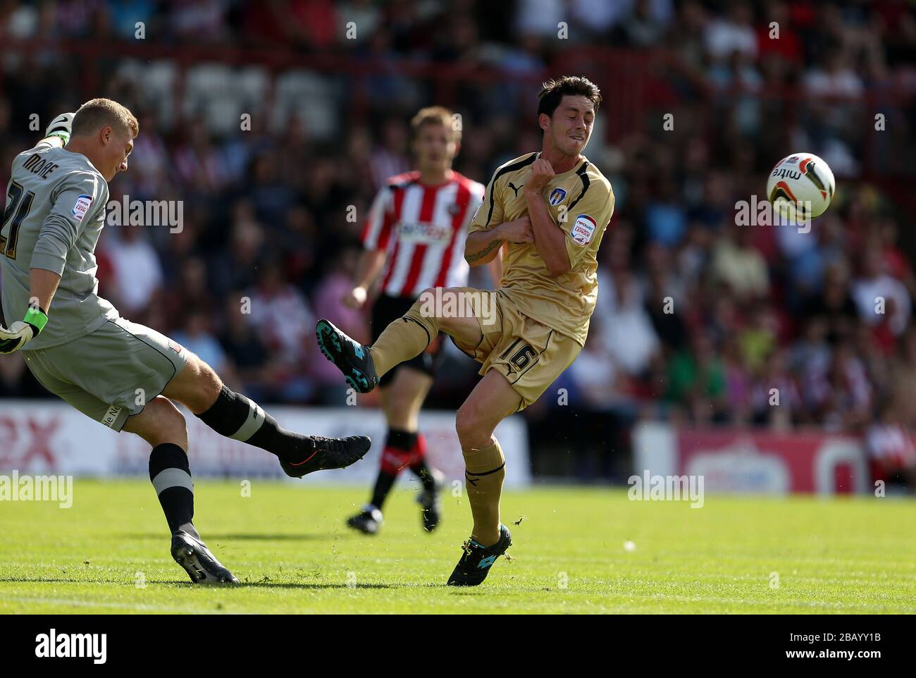 Simon Moore, portiere di Brentford, libera la palla sotto pressione da Ian Henderson, del Colchester United Foto Stock