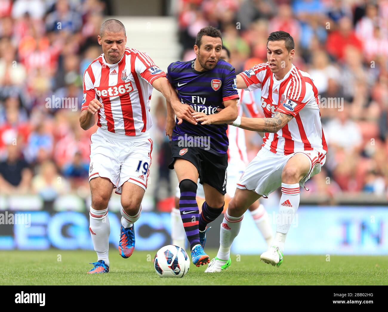 Jonathan Walters di Stoke City (a sinistra) e Geoff Cameron (a destra) e la battaglia di Santi Cazorla dell'Arsenal per la palla Foto Stock