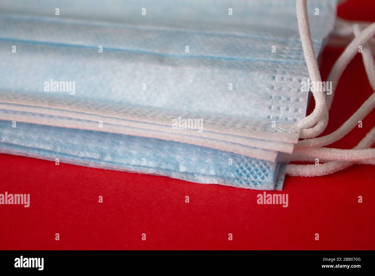 Maschere mediche su sfondo rosso. Pandemia disinvoltura diffusione in tutto il mondo. Trattamento medico delle persone infette. Assistenza sanitaria Foto Stock