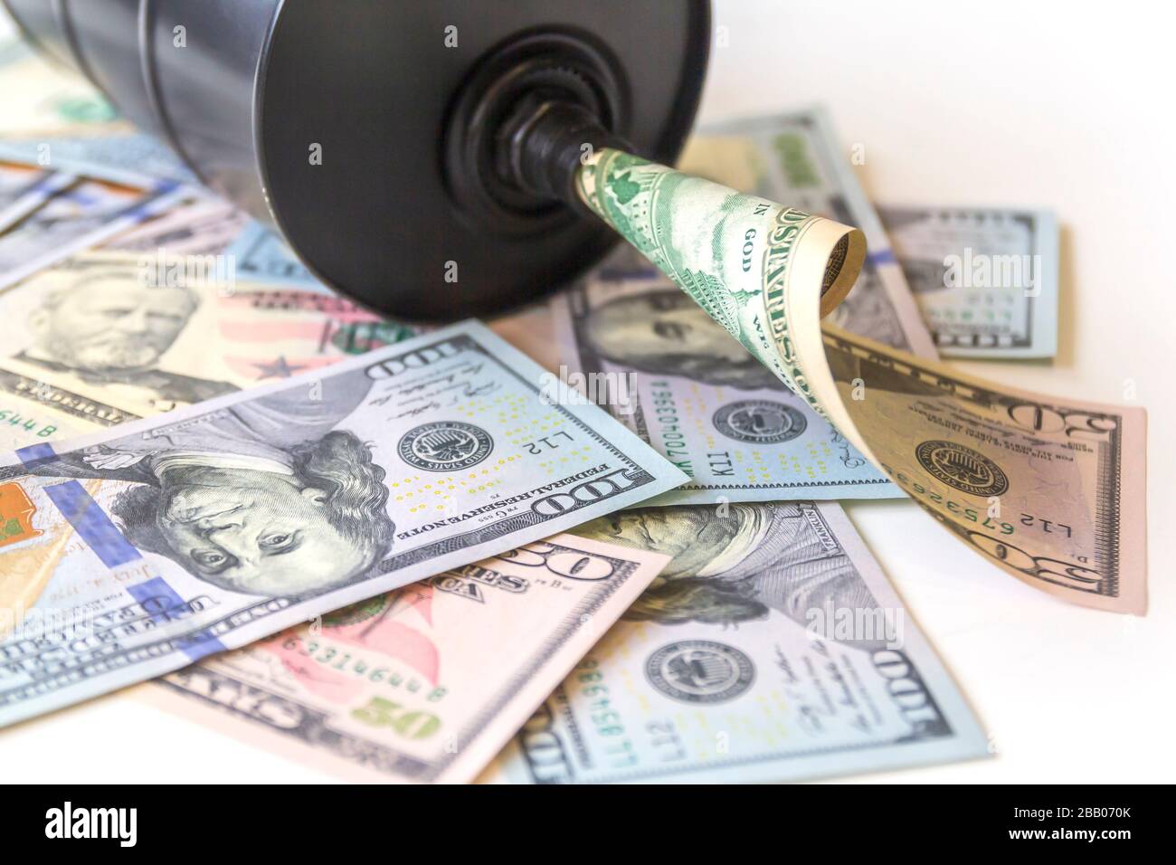 Barile di petrolio su uno sfondo, dollari americani background. Trend in calo della diminuzione dei prezzi al barile degli utili e dell'economia globale . Messa a fuoco selettiva. Foto Stock