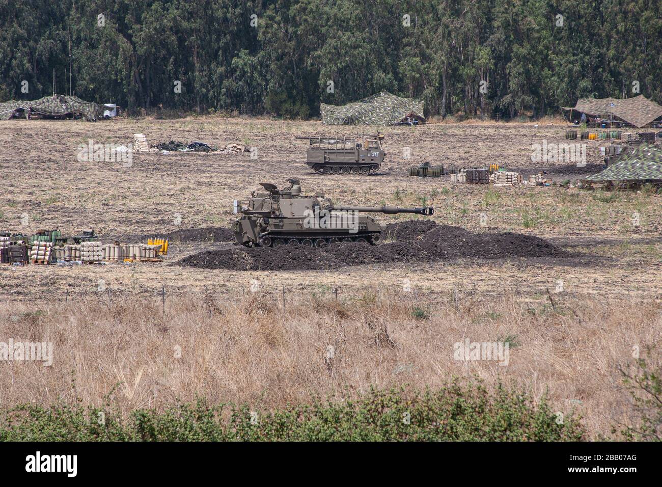 Le truppe israeliane si trovano accanto ai veicoli corazzati di artiglieria che si sono schierati vicino al confine tra Israele e Libano. Foto Stock