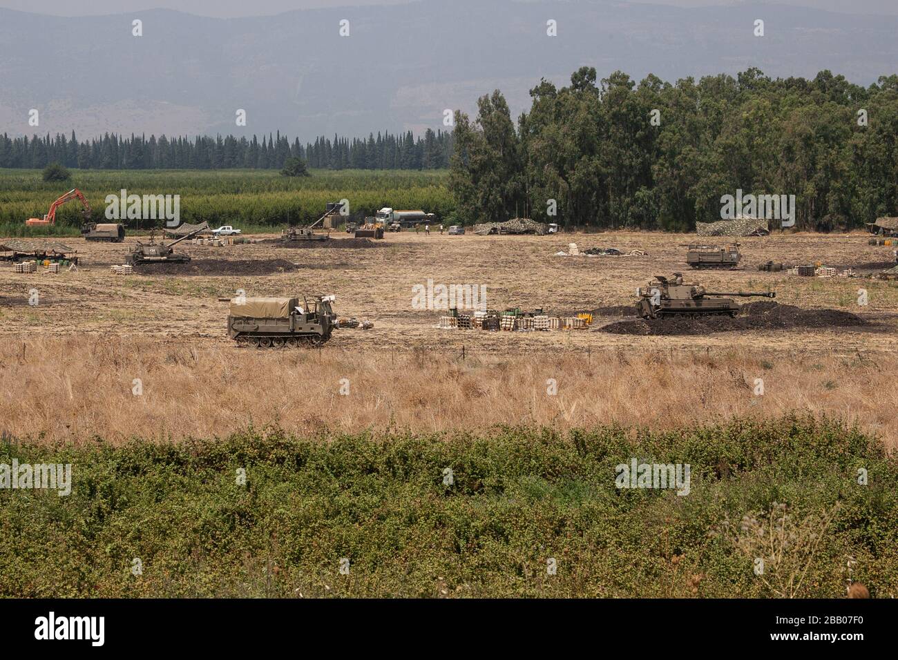 Le truppe israeliane si trovano accanto ai veicoli corazzati di artiglieria che si sono schierati vicino al confine tra Israele e Libano. Foto Stock