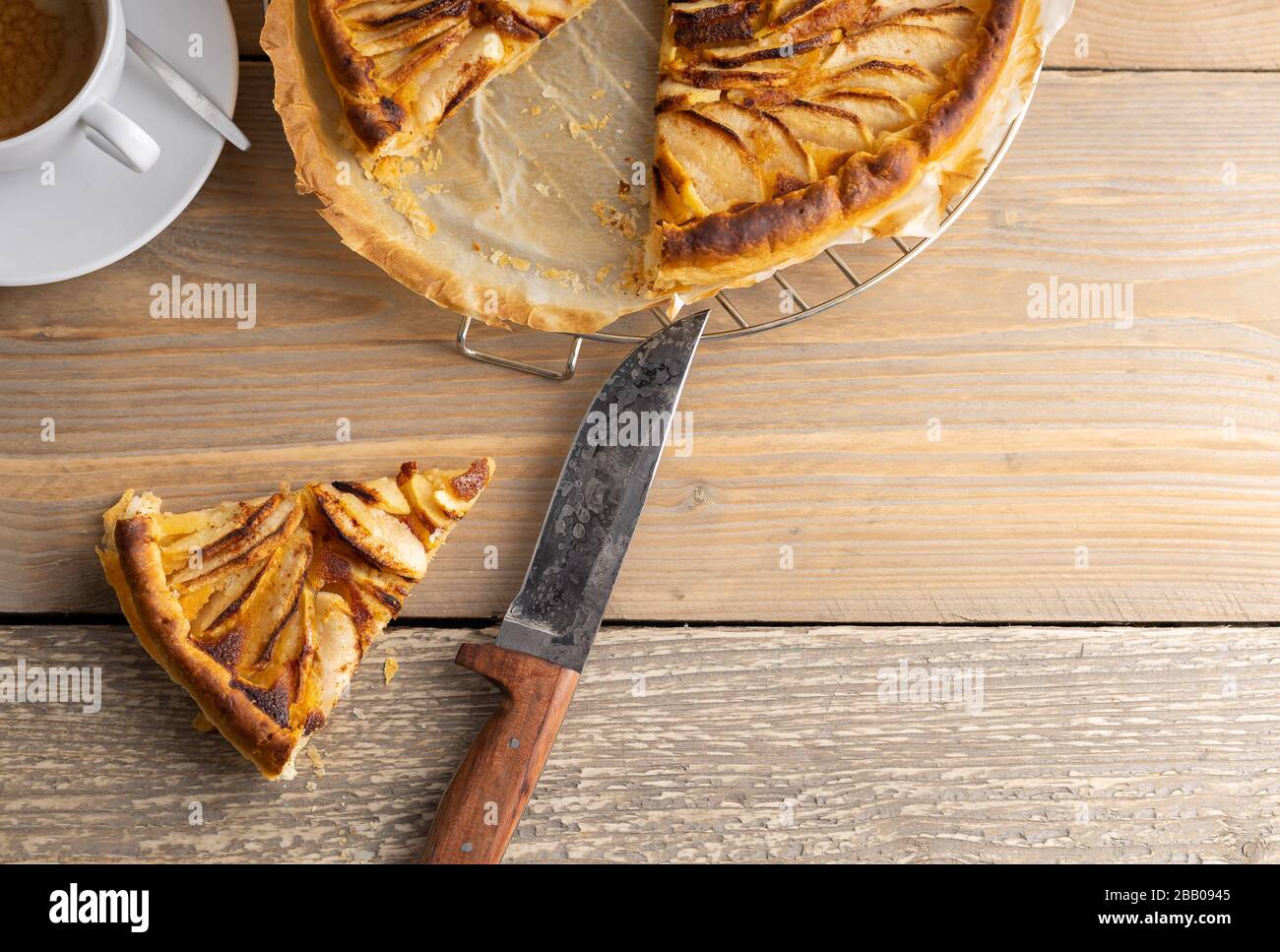 Torta di mele cotta in casa su un tavolo di legno con una tazza di caffè sul lato. Vista dall'alto. Foto Stock
