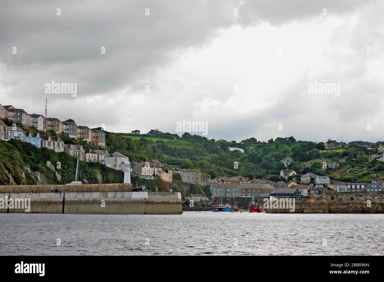 Il piccolo villaggio di pescatori della Cornovaglia di Mevagissey che si apre tra le mura del porto dal Seaward: Cornovaglia, Inghilterra, Regno Unito Foto Stock