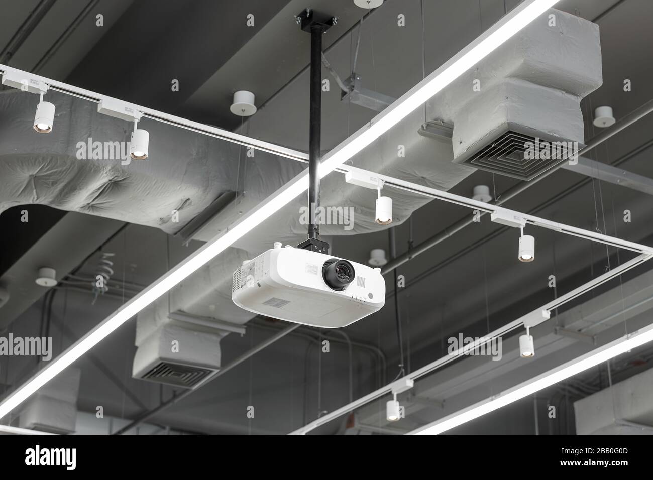 Un proiettore sospeso bianco e un condizionatore d'aria montato a soffitto  al chiuso Foto stock - Alamy
