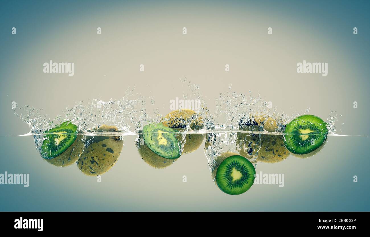 kiwi che cadono in acqua e creare schizzi. concetto di cibo sano e fresco, dieta e salute. rendering 3d. Foto Stock