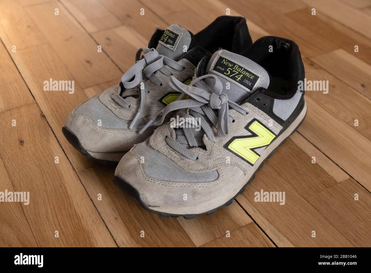 Vecchio paio di nuovo equilibrio 574 scarpe da training su pavimento in legno duro Foto Stock