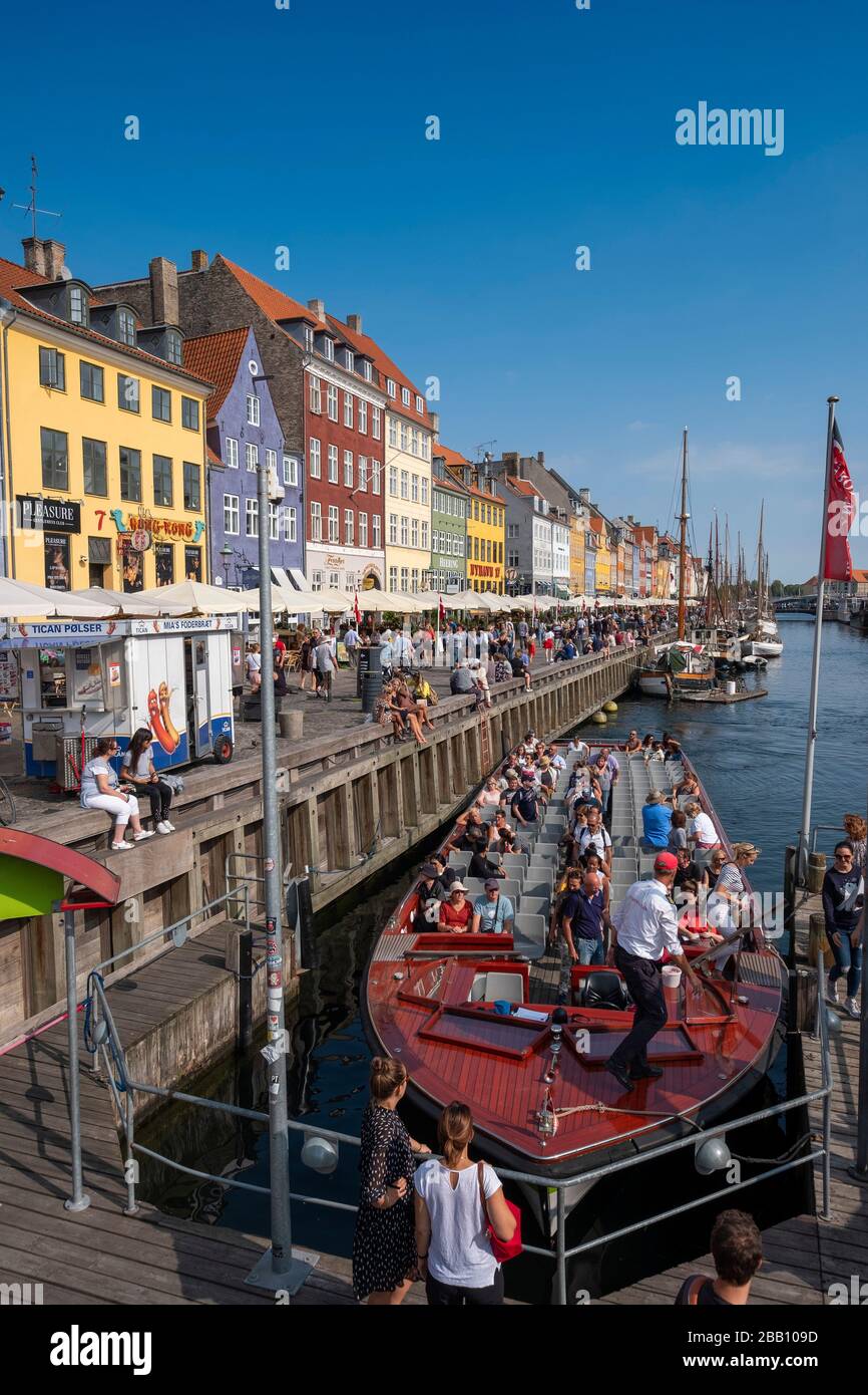 Le persone che sbarcano da una barca turistica al molo sul canale Nyhavn a Copenhagen, Danimarca, Europa Foto Stock