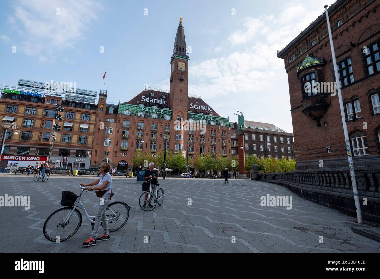 Persone con biciclette sulla Rådhuspladsen con lo Scandic Palace Hotel sullo sfondo, Copenaghen, Danimarca, Europa Foto Stock