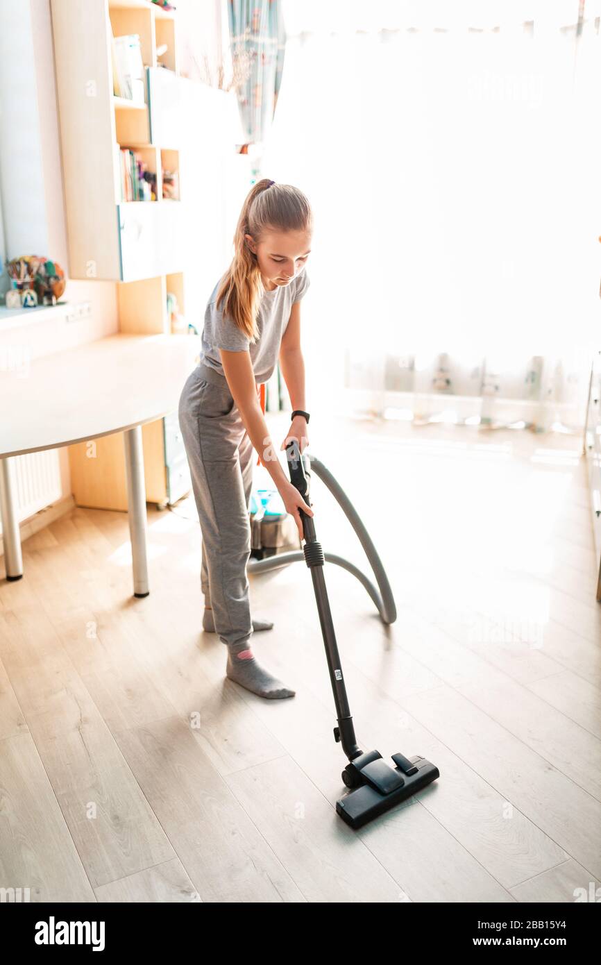 Ragazza adolescente che pulisce la sua stanza con aspirapolvere. La  comodità dei bambini e le pulizie aiutano a concepire il concetto Foto  stock - Alamy