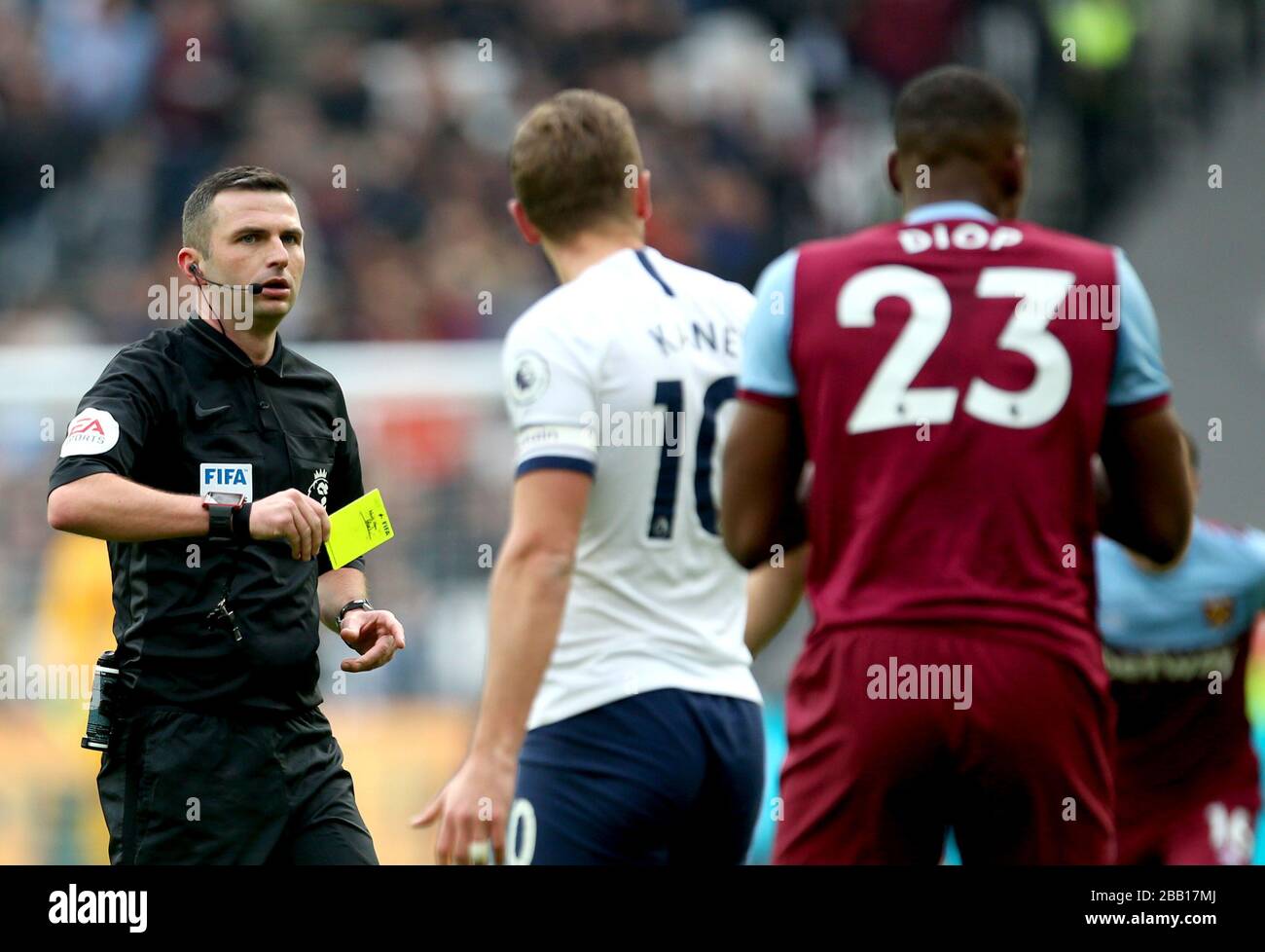 L'arbitro Michael Oliver mostra una carta gialla per la West Ham United's Issa Diop (a destra) Foto Stock