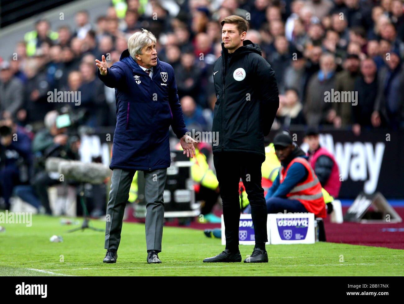 Il manager del West Ham United Manuel Pellegrini (a sinistra) si lamenta di un quarto funzionario dopo che l'Issa Diop del West Ham United riceve una carta gialla Foto Stock