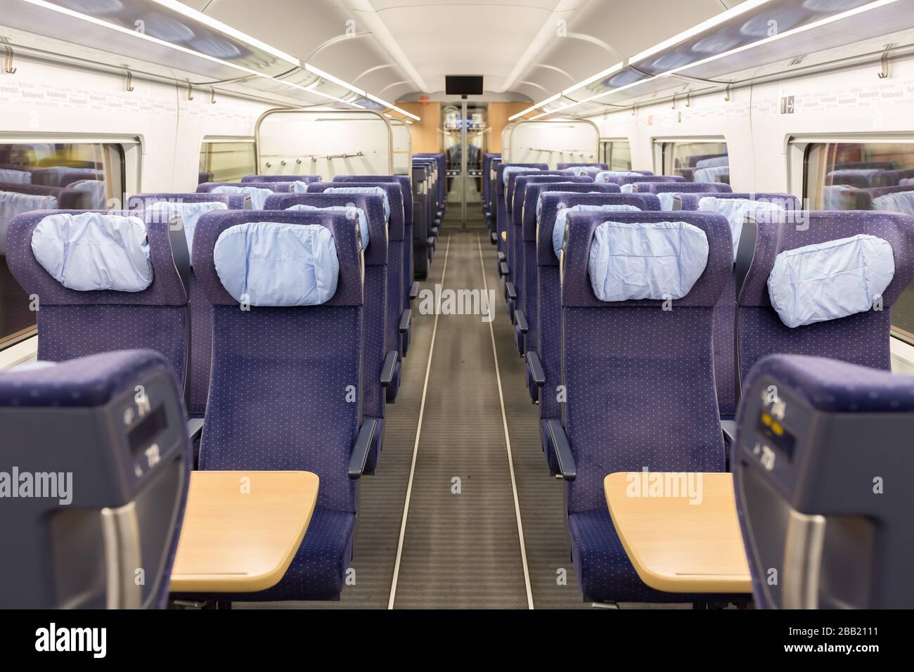 Interno di un treno vuoto ICE (Intercity Express) della Deutsche Bahn (DB). Vista in linea retta lungo la corsia/passerella con sedili blu su entrambi i lati. Foto Stock