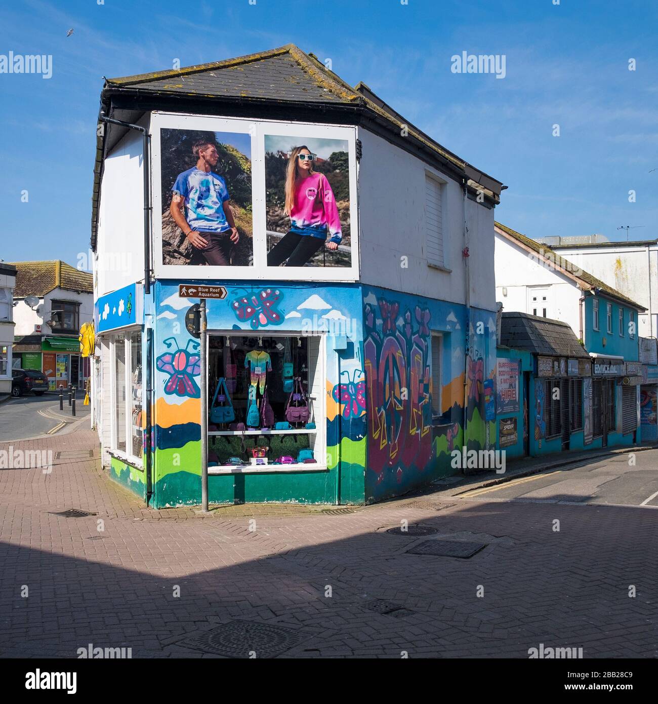 Un negozio di abbigliamento ad angolo con pareti colorate nel centro di Newquay Town in Cornovaglia. Foto Stock