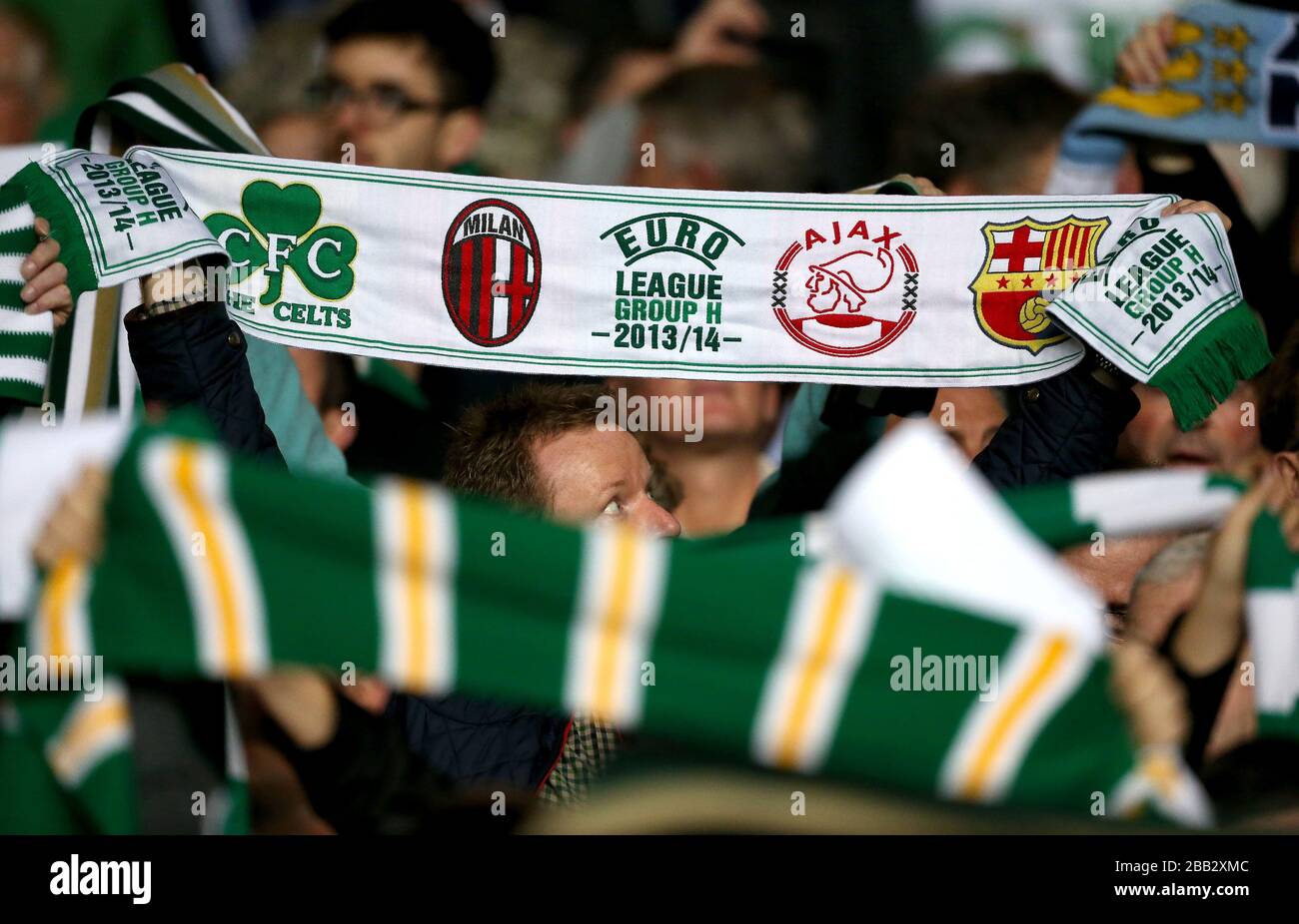 I ventilatori celtici tengono in su le sciarpe per mostrare il loro sostegno nelle tribune Foto Stock