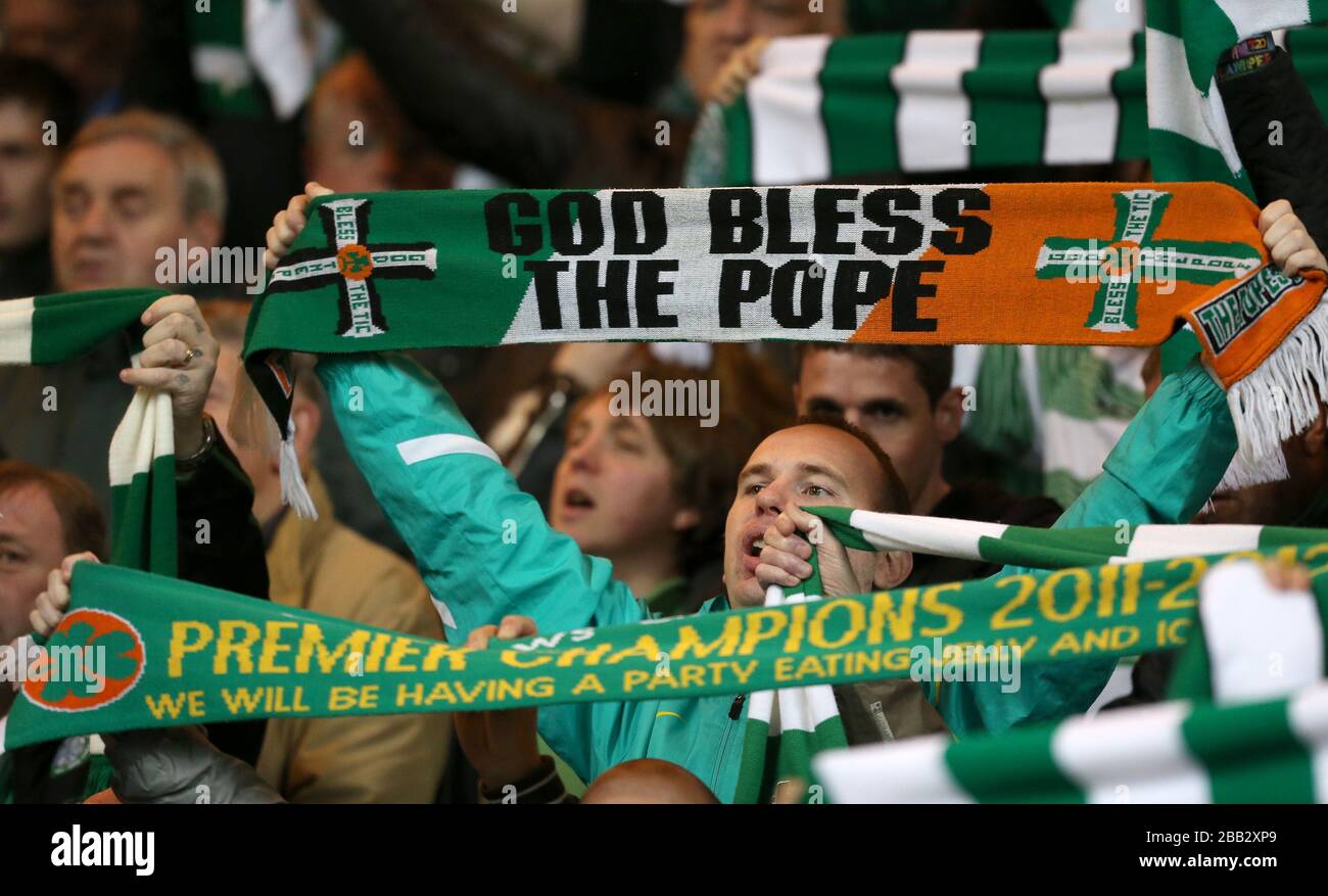 I ventilatori celtici tengono in su le sciarpe per mostrare il loro sostegno nelle tribune Foto Stock