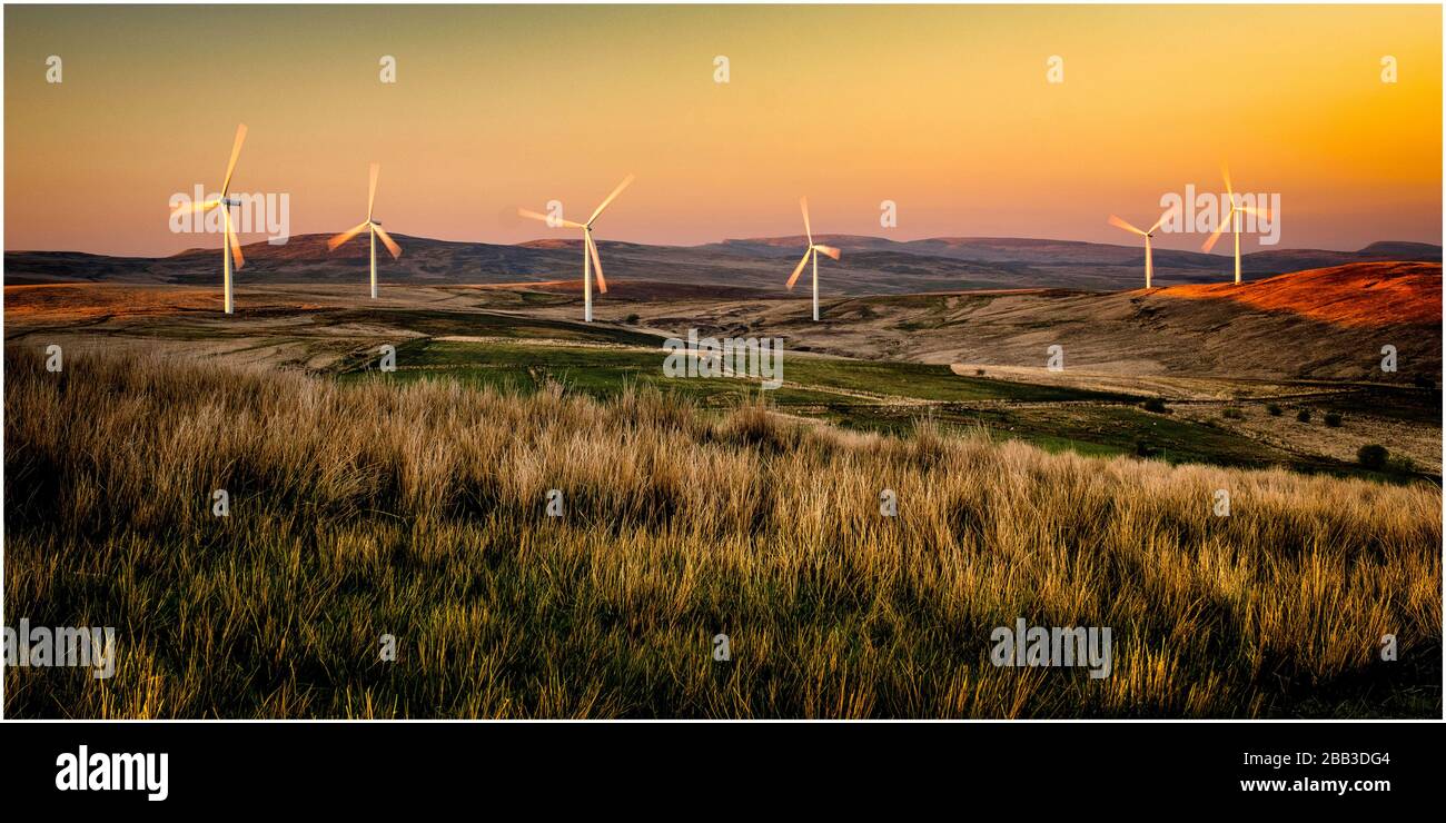 Parco eolico nelle altipiani gallesi al tramonto Foto Stock