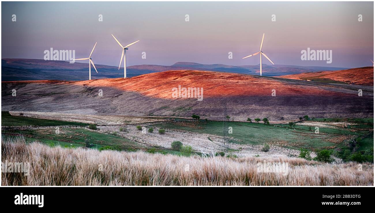 Le turbine eoliche su una collina al tramonto Foto Stock