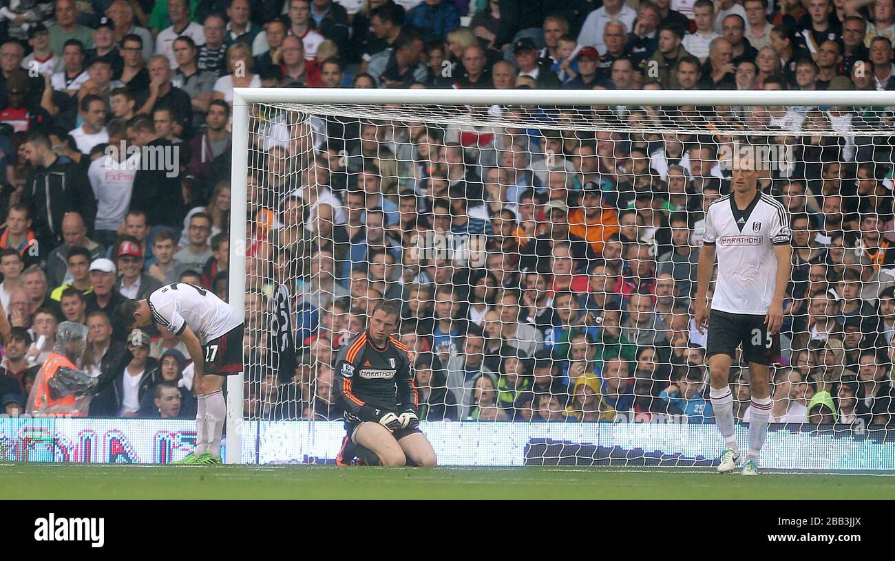 I giocatori di Fulham si levano in piedi dejected dopo che Lukas Podolski dell'Arsenal ha ottenuto il secondo obiettivo del suo lato del gioco Foto Stock