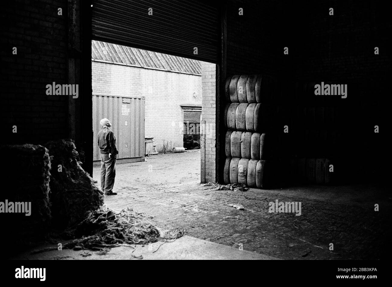 Un lavoratore in attesa di una consegna al mulino Tay Spinners di Dundee, in Scozia. Questo stabilimento è stato l'ultimo filatoio di iuta in Europa quando è stato chiuso per l'ultima volta nel 1998. La città di Dundee era stata famosa per la storia dei tre 'JS' - juta, jam e giornalismo. Foto Stock