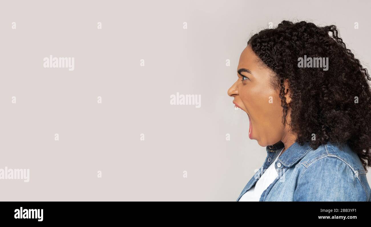 Arrabbiata donna afroamericana urlando con rabbia a copia spazio Foto Stock