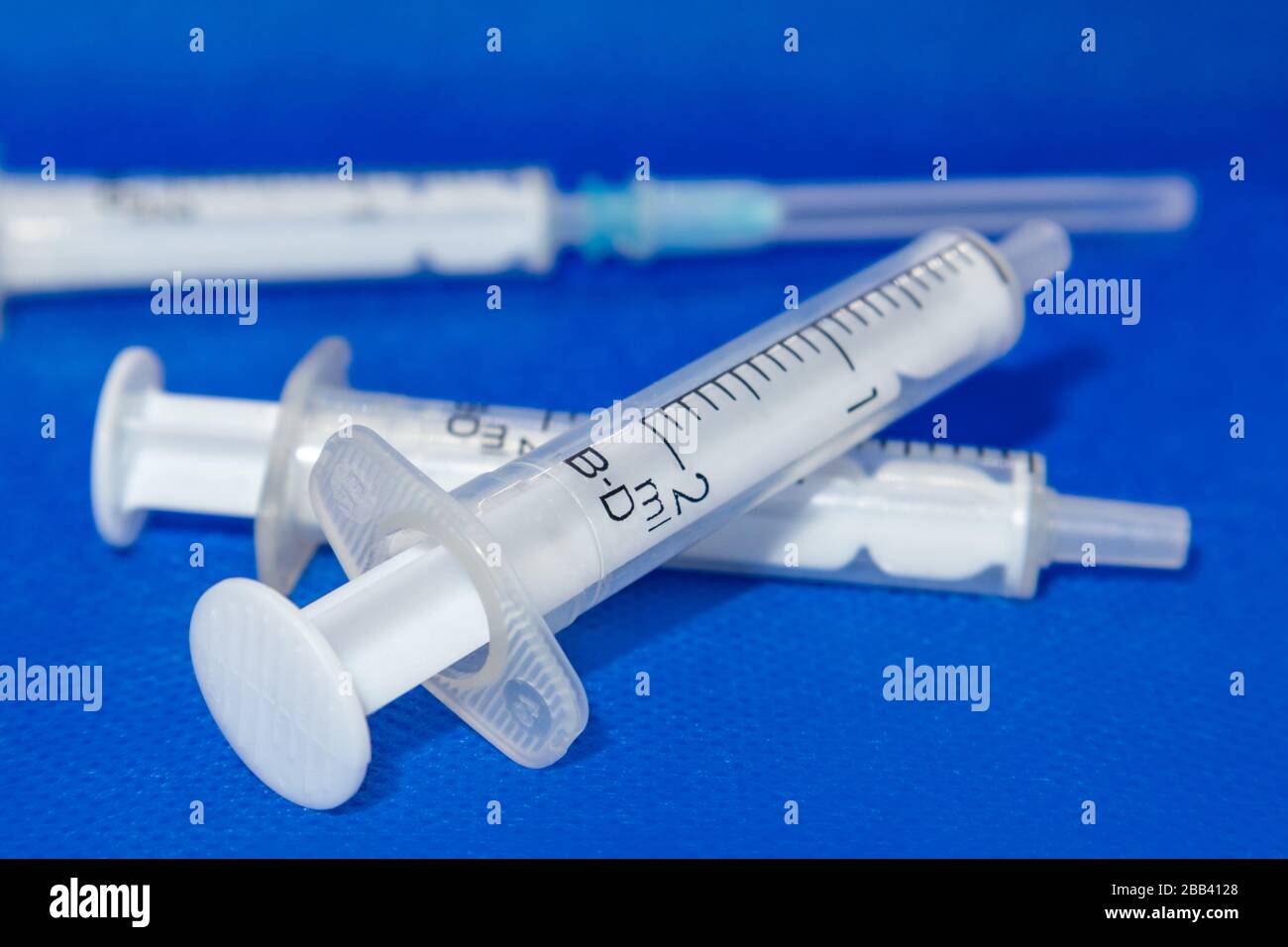 Siringhe da 2 ml bianche macro da primo piano su superficie vibrante blu. Medicinale per iniezione, vaccino, cura Foto Stock