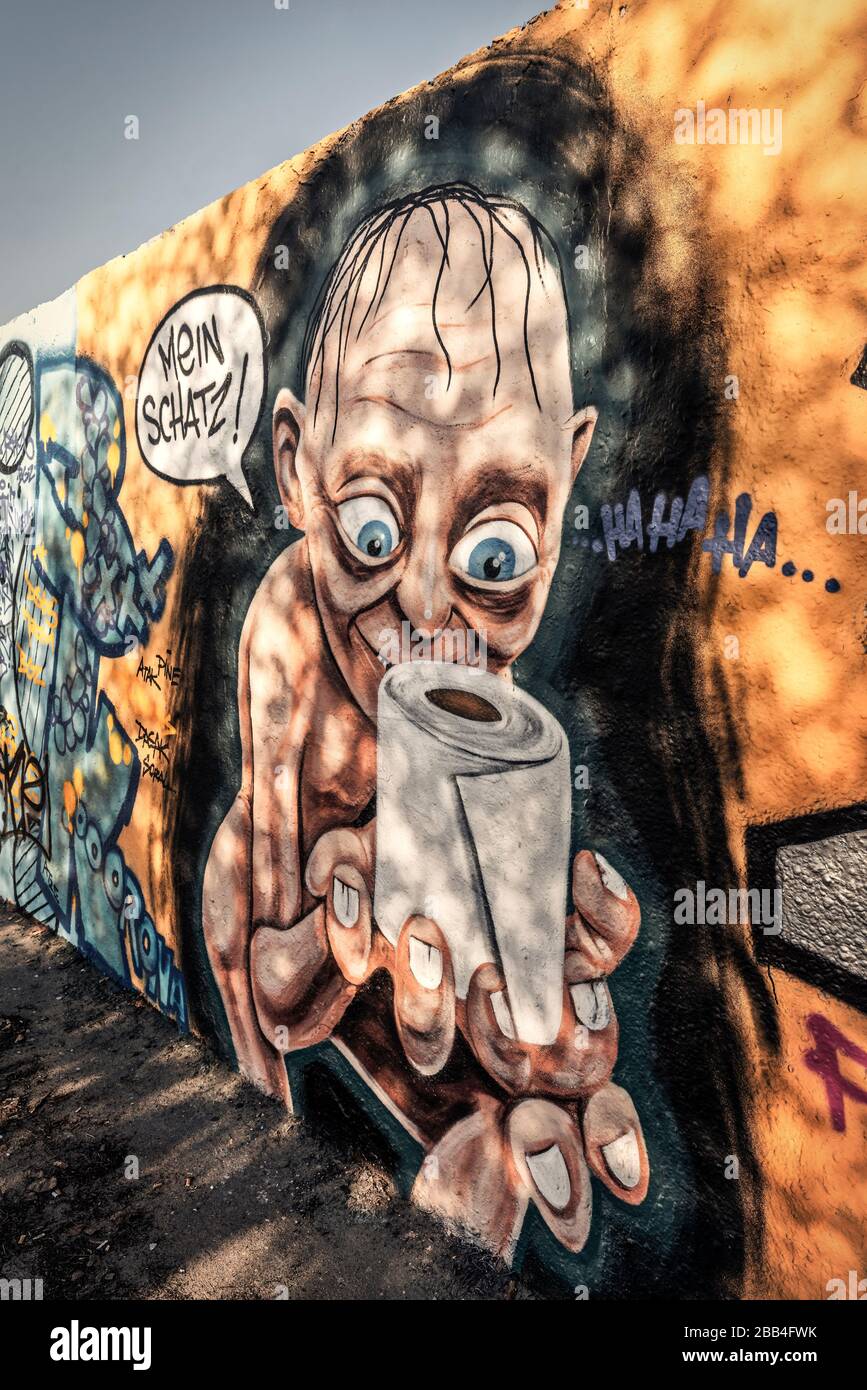 Graffiti sulla crisi del Corona a Mauerpark a Berlino Prenzlauer Berg . Graffiti con Gollum dal Signore degli anelli con carta igienica e speec Foto Stock