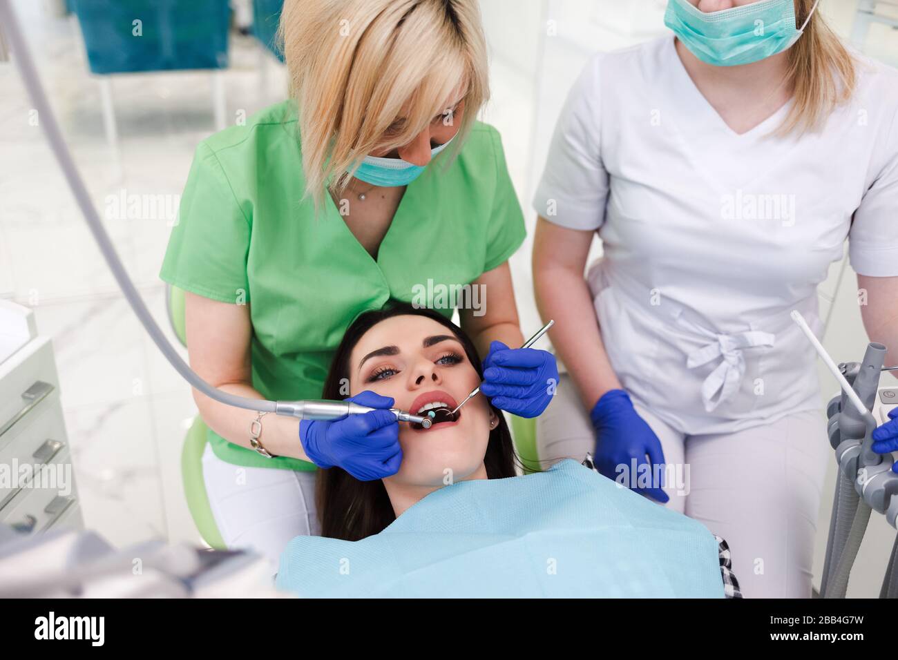 Dentista e assistente trattano i denti di un paziente Foto Stock