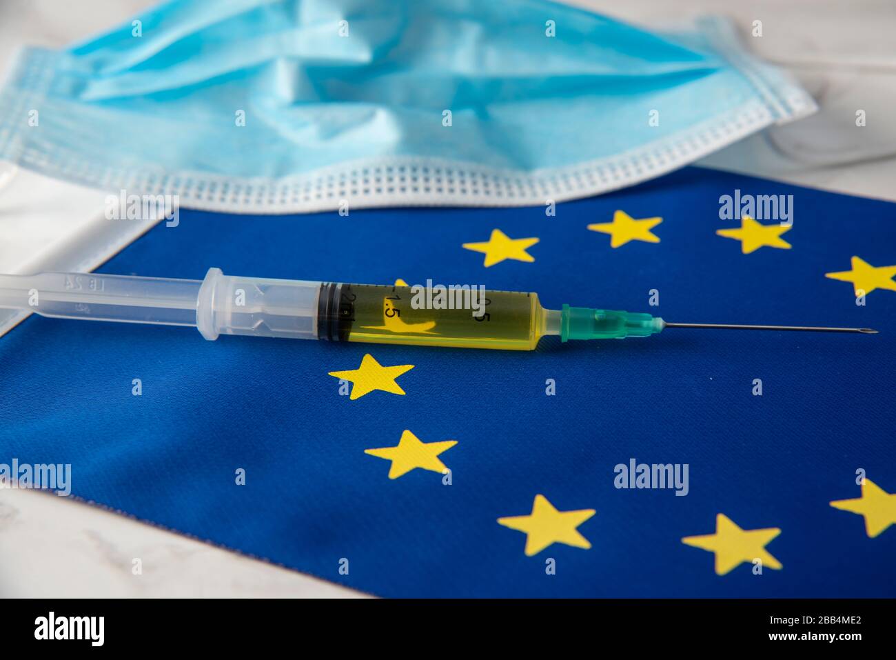 costo della ripartizione del coronavirus in europa maschera medica e vaccino sulla bandiera europea Foto Stock