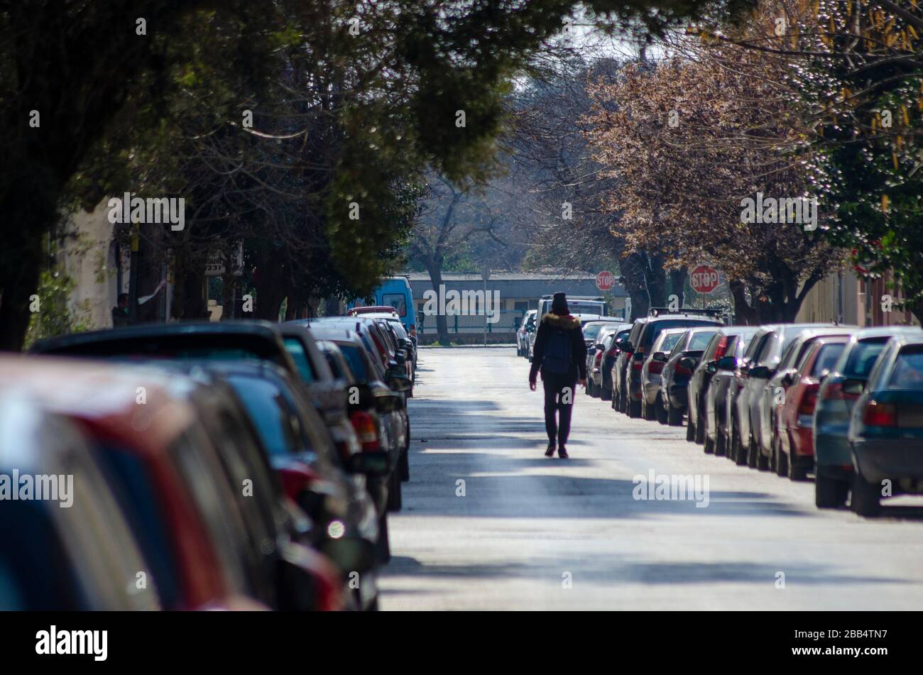 ALEXANDROUPOLI, GRECIA - 21 Mar 2020 - una persona sola cammina nel mezzo della strada in Alexandroupoli Grecia durante il blocco COVID-19. Foto Stock