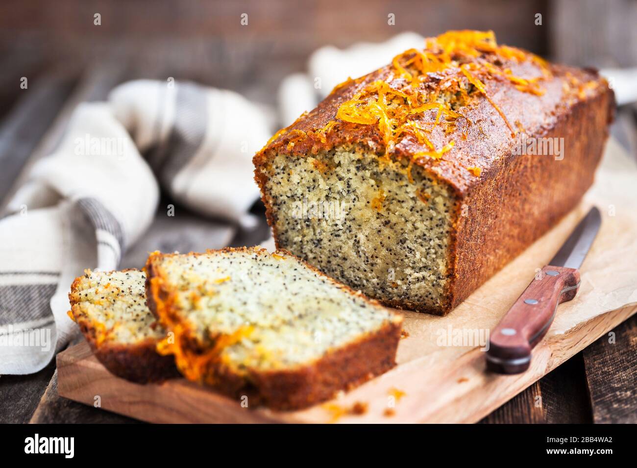 Deliziosa torta di pane fatta in casa con semi di papavero e arancia su sfondo rustico in legno Foto Stock