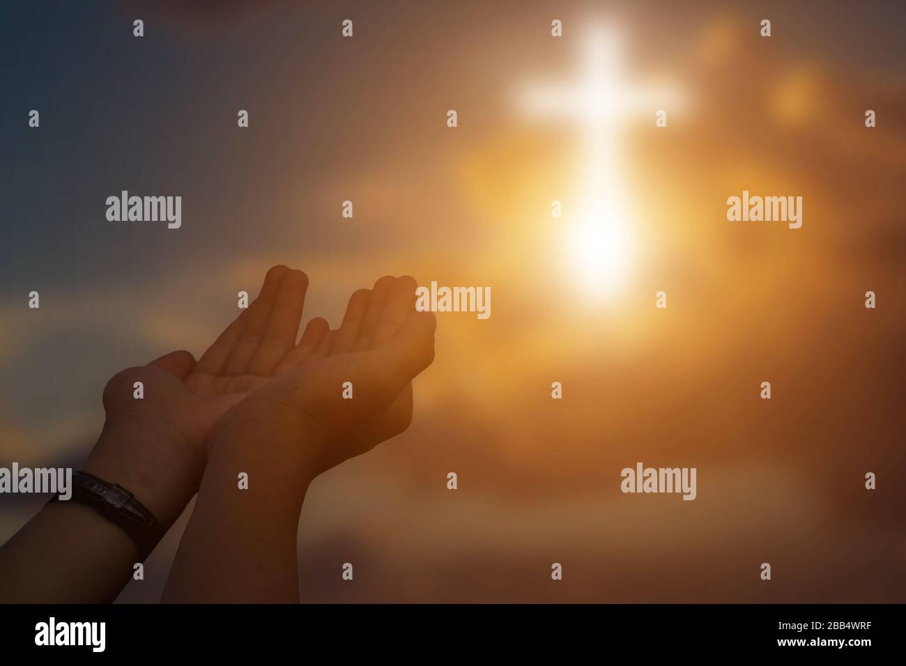 Silhouette di mani aperte cristiane a pregare per la benedizione da dio al tramonto sfondo. Foto Stock