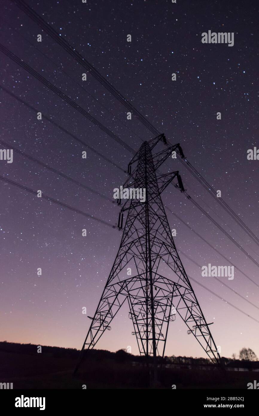Stelle nel cielo notturno visto dietro pilone elettricità in Sussex, Regno Unito, marzo Foto Stock