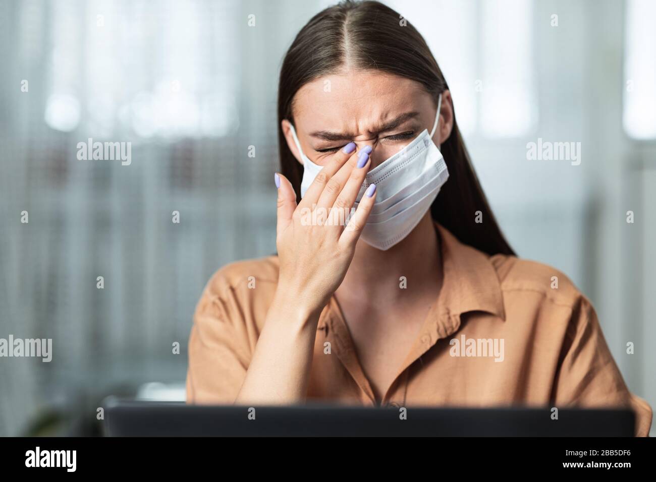 Ritratto di donna in quarantena che indossa la maschera che tocca l'occhio Foto Stock