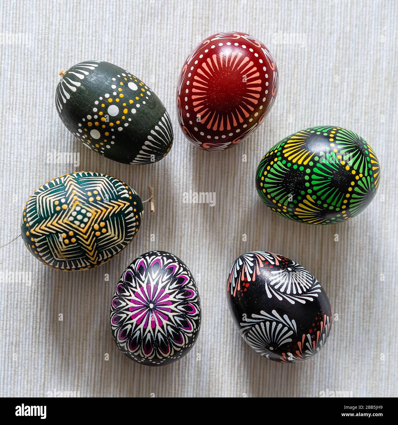 Sei uova di Pasqua multicolori lituano tradizionale dipinto con cera d'api su uno sfondo marrone a righe. Naturale, per decorazione, ceramica Foto Stock