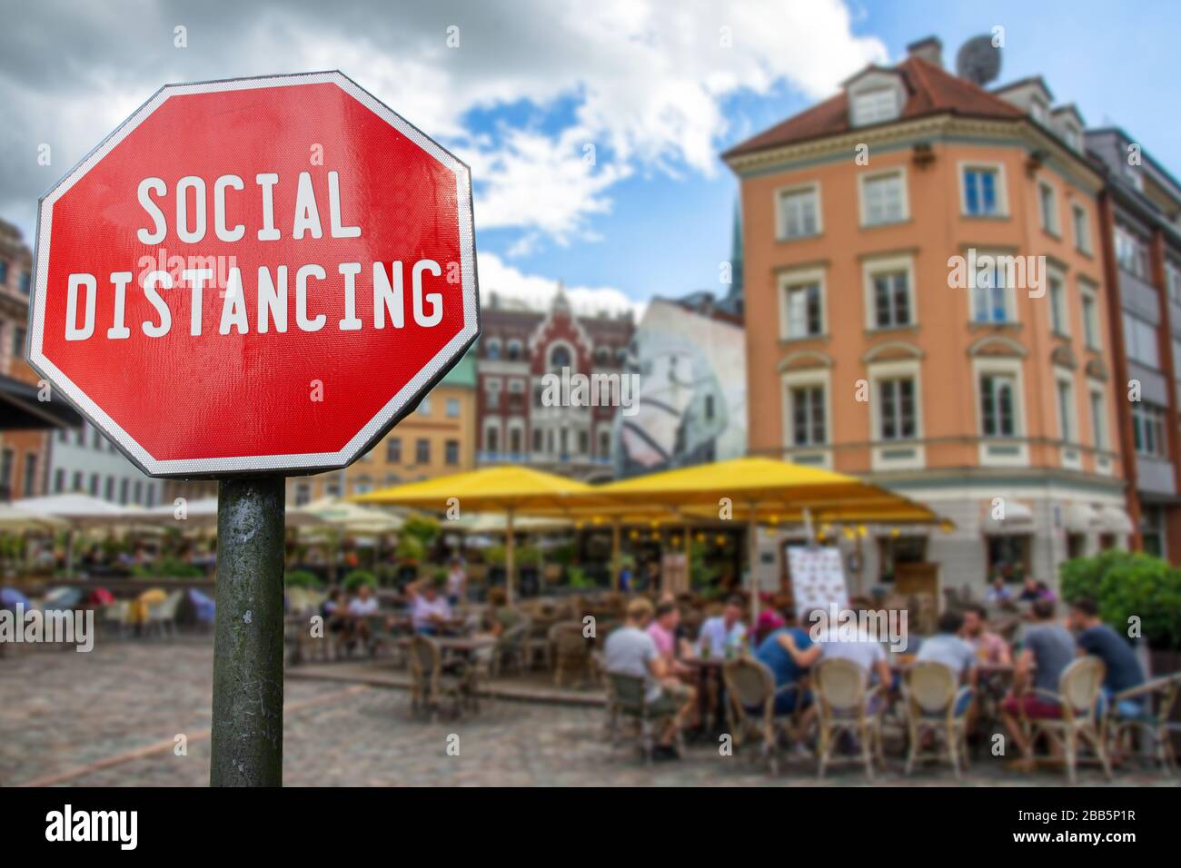 Concetto di distanza sociale. Segno con la parola di distanza sociale con caffè con la gente sfondo sfocato. Misure preventive per il contenimento del virus corona Foto Stock