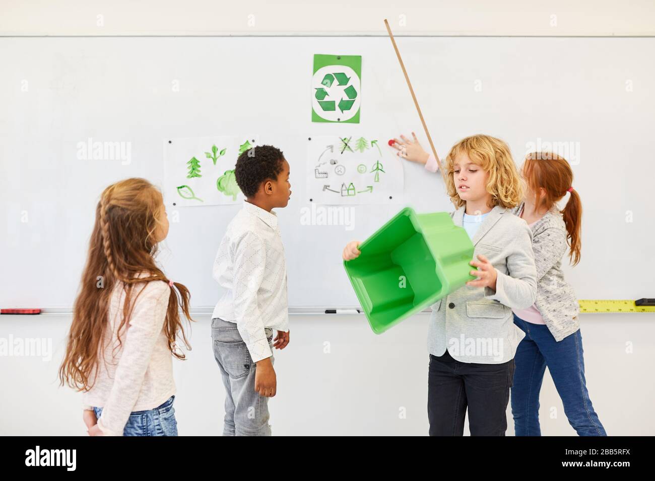 Il gruppo di bambini della scuola elementare dà una lezione sulla tutela ambientale e sul riciclaggio in classe Foto Stock