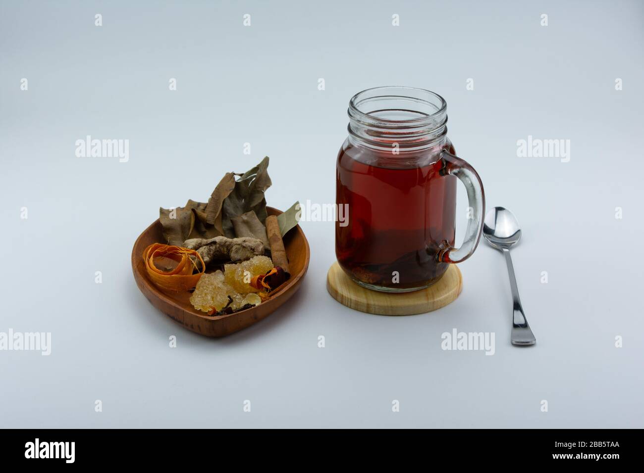 Un bicchiere di tè allo zenzero e varie erbe. Foto Stock