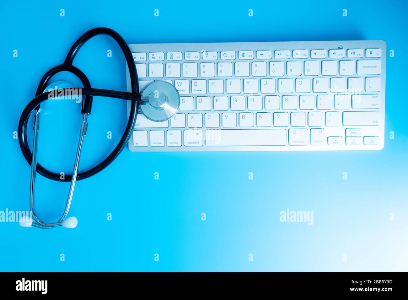 Assistenza sanitaria e medicina o computer antivirus protezione e riparazione manutenzione concetto: Macro vista di stetoscopio blu sul giro di ufficio Foto Stock