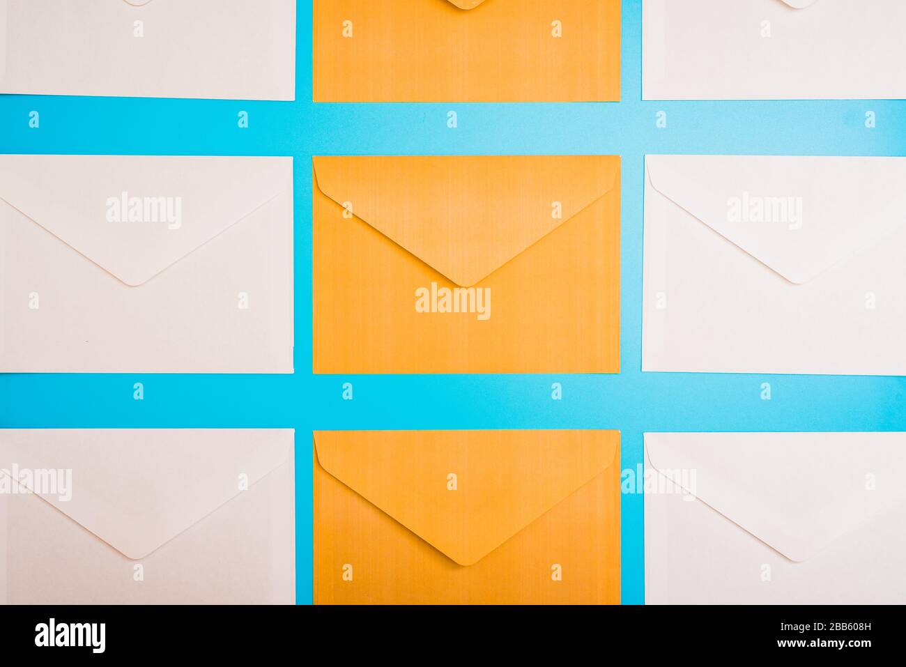 Sfondo ripetitivo con buste di carta arancione e blu su un tavolo da ufficio che invia lettere. Foto Stock