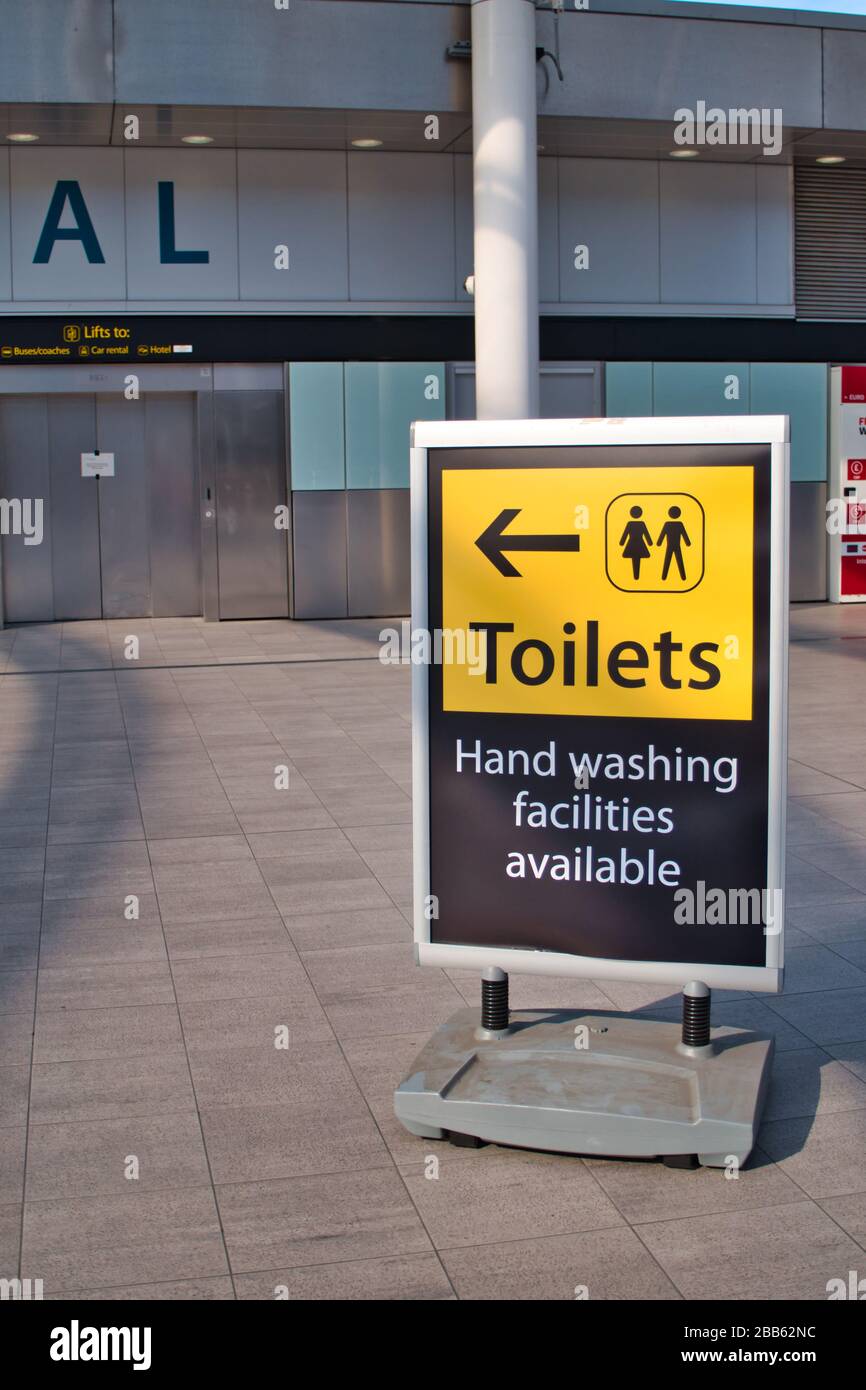 Un cartello al deserte Terminal Sud dell'Aeroporto di Gatwick indica la strada per i servizi igienici e le attrezzature per il lavaggio delle mani durante l'emergenza del coronavirus Foto Stock